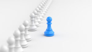 Leadership concept, blue pawn of chess, standing out from the crowd of white pawns, on white background with empty copy space. 3D Rendering