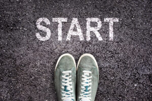Sneaker shoes and the word START written on asphalt ground, new life concept