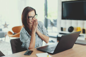 Happy young modern businesswoman reading good news on laptop